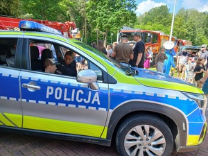 zdjęcie przedstawia dziecko siedzące w radiowozie