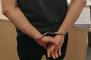 Mężczyzna w kajdankach spietych z tyłu